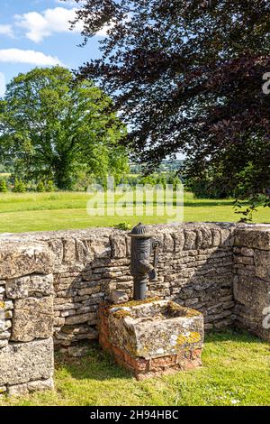 Die alte Dorfwasserpumpe im Cotswold-Dorf Yanworth, Gloucestershire, Großbritannien Stockfoto