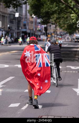 Melbourne, Australien, 4. Dezember 2021. Ein Protestler drapierte während des letzten „aufhebungsmarsches des Gesetzentwurfs“ mit einer roten australischen Flagge, an dem Tausende Demonstranten vom parlamentsgebäude zur Flinders Street Station marschierten, um die Kreuzung zu halten. Demonstranten marschierten in den Büros des ABC- und Regierungshauses. Quelle: Michael Currie/Speed Media/Alamy Live News Stockfoto