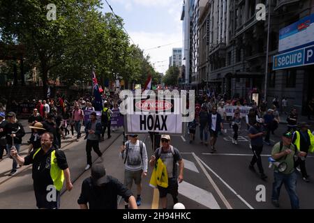 Melbourne, Australien, 4. Dezember 2021. Ein Protestler mit einem Schild „Gefahr-Hoax“ in der Menge auf der Flinders Street während des letzten „aufhebungsmarsches des Gesetzes“, an dem Tausende Demonstranten vom parlamentsgebäude zur Station in der Flinders Street marschierten, um die Kreuzung zu halten. Demonstranten marschierten in den Büros des ABC- und Regierungshauses. Quelle: Michael Currie/Speed Media/Alamy Live News Stockfoto