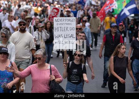 Melbourne, Australien, 4. Dezember 2021. Ein Protestler mit einem Hitler-Schiedsrichter-Plakat in der Menge auf der Flinders Street während der letzten „Aufhebung des Gesetzes“-parade von Tausenden Demonstranten vom parlamentsgebäude zur Flinders Street Station, um die Kreuzung zu halten. Demonstranten marschierten in den Büros des ABC- und Regierungshauses. Quelle: Michael Currie/Speed Media/Alamy Live News Stockfoto