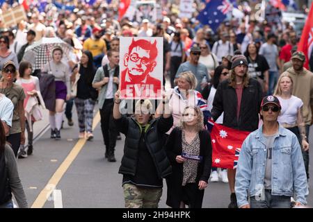 Melbourne, Australien, 4. Dezember 2021. Ein Protestler mit einem „bösen“ Plakat in der Menge auf der Flinders Street während des letzten „aufhebungsmarsches des Gesetzes“, an dem Tausende Demonstranten vom parlamentsgebäude zur Flinders Street Station marschierten, um die Kreuzung zu halten. Demonstranten marschierten in den Büros des ABC- und Regierungshauses. Quelle: Michael Currie/Speed Media/Alamy Live News Stockfoto