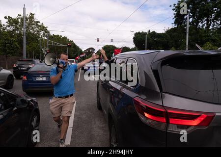 Melbourne, Australien, 4. Dezember 2021. Ein Protestierender mit fünf hohen Bannern fährt einen Passagier in einem Auto, während die Demonstranten während des letzten „aufhebungsmarsches“ von Tausenden Demonstranten vom parlamentsgebäude zur Flinders Street Station marschieren, um die Kreuzung zu halten. Demonstranten marschierten in den Büros des ABC- und Regierungshauses. Quelle: Michael Currie/Speed Media/Alamy Live News Stockfoto