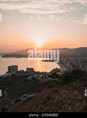 Vertikale Aufnahme des Stadtbildes von Benidorm, Spanien bei Sonnenuntergang Stockfoto