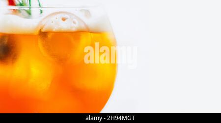 Ein Glas eisgekühlter Aperol Spritz-Cocktail aus nächster Nähe wird in einem Weinglas auf weißem Hintergrund serviert. Stockfoto