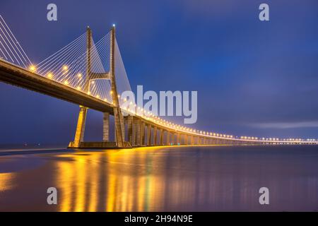 Die imposante Vasco da Gama-Brücke über den Fluss Tejo in Lissabon, Portugal, blieb nachts über die Kabel hängen Stockfoto