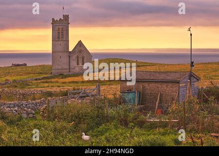 Sonnenaufgang über der St. Helen's Church Blick über überwuchert Schrebergarten auf Lundy Island, Bristol Channel, Devon, England, Großbritannien Stockfoto