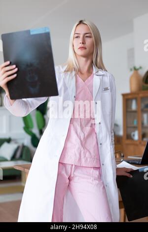 Ärztin schaut sich den Röntgenscan im Büro an. Stockfoto