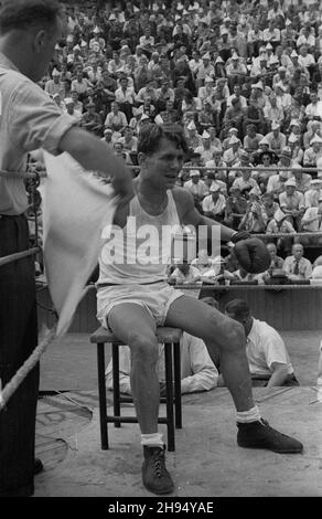 Warszawa, 1947-07-20. Korty tenisowe Wojskowego Klubu Sportowego Legia. Towarzyski mecz bokserski pomiêdzy reprezentacj¹ polskiej Milicji Obywatelskiej (MO) i milicji wêgierskiej. NZ. piêœciarz kategorii lekkiej Antkiewicz, wachlowany przez sekundanta w naro¿niku. bk/pp PAP Warschau, 20. Juli 1947. Tennisplätze des Legia Military Sport Club. Ein Freundschaftsspiel zwischen polnischen und ungarischen Milizen. Im Bild: Leichtes Match zwischen Antkiewicz (1st von rechts) und Szabo. Der polnische Boxer mit dem Eckpfeiler. bk/pp PAP Stockfoto