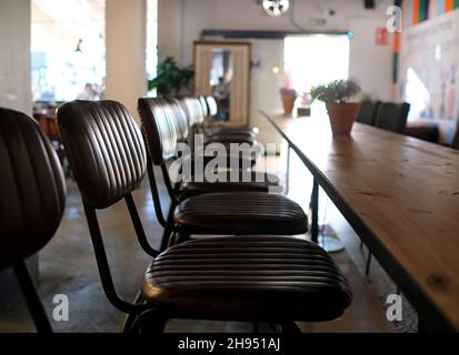 Reihe von Ledersitzen neben einem Holztisch Stockfoto