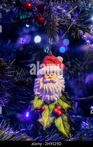 Vater Weihnachtsdekoration hängt an einem Weihnachtsbaum mit blauen und weißen Lichterketten. Stockfoto