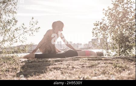 Massagetherapeutin wendet ihre Massagefähigkeiten auf ihren Klienten auf dem Gras an. Stockfoto