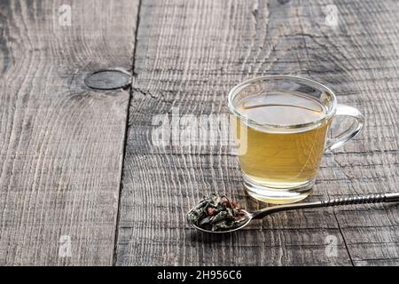 Grüner Tee mit Goji-Beere in Glasschale auf Holztisch Stockfoto