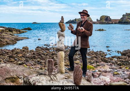 James Craig Page, Stone Stacker und Organisator der European Stone Stacking Championship, kreiert Steinskulpturen, Dunbar, East Lothian, Schottland, Großbritannien Stockfoto