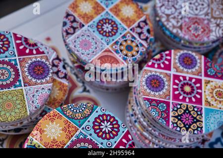 Ein Haufen bunt dekorierter Untersetzer in einem Souvenirladen in Palermo Stockfoto