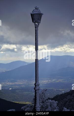 Alte Lampe Pfosten im Raureif stehend auf dem Rand eines Hügels an einem düsteren Tag Stockfoto