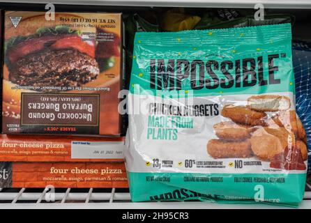 MORGANTOWN, WV - 4. November 2021: Verpackung für Impossible Foods Chicken Nuggets im heimischen Gefrierschrank neben Büffelburgern Stockfoto