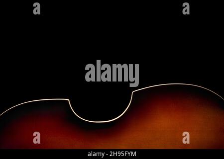 Rückseite des Sunburst Bassgitarre auf Unterseite des Bildes auf schwarzem Hintergrund Stockfoto