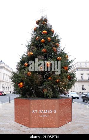 Vor dem Sofitel St James in London steht ein umwerfender Weihnachtsbaum, der mit einem eleganten Stern geschmückt ist. Stockfoto