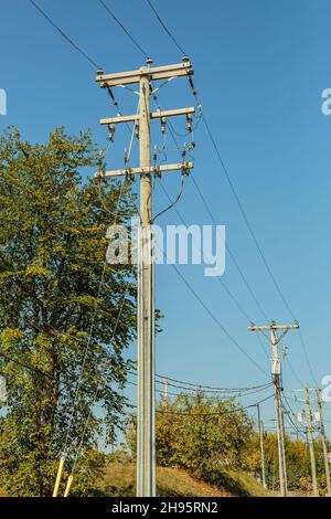 Utility Beiträge für Telefon, Strom und Kabel unter einem blauen Himmel Stockfoto