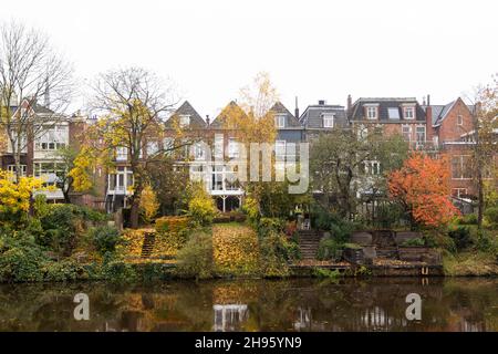 Häuser und Bäume in Herbstfarben säumen den Verbindungskanaal entlang des Zuiderparks in Groningen, Niederlande. Stockfoto