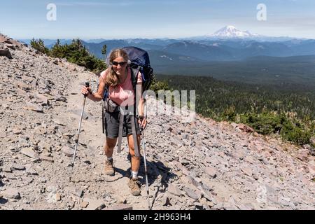 WA20471-00....WASHINGTON - Vicky Spring Wandern in der Nähe von High Camp in der Mount Adams Wildnis mit Mount Rainier in der Ferne. Stockfoto