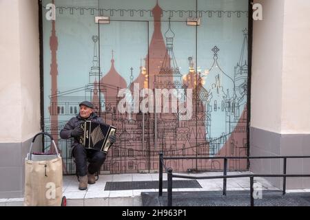 Moskau, Russland. 04th. Dezember 2021 Spielt Der Straßenmusiker die Ziehharmonika auf der Nikolskaja Straße im Zentrum Moskaus, Russlands Stockfoto