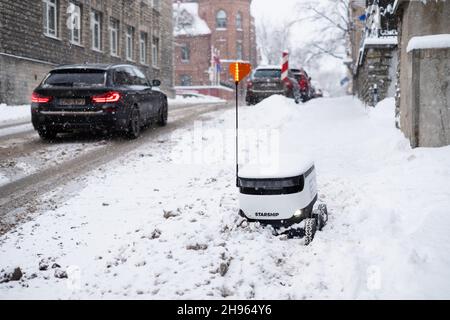 Tallinn, Estland - 4. Dezember 2021: Raumschiff Technologies autonomes Drohnenfahrzeug im Winter im Schnee stecken geblieben. Selbstfahrende kontaktlose Zustellroboter. Stockfoto