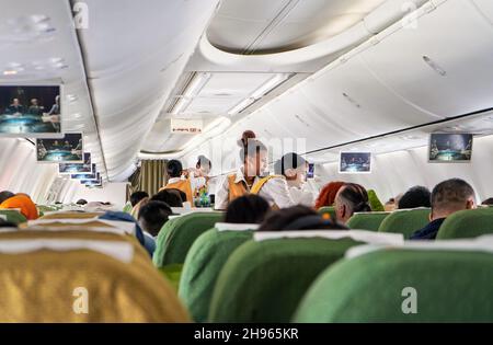 Addis Abeba, Äthiopien - 23. April 2019: Passagierinnenraum während des Fluges, Passagiere sitzen, Gepäckfächer geschlossen, afrikanische Frauen sind dabei Stockfoto