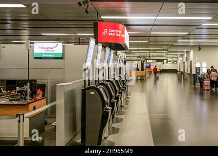 Schwechat, Österreich - 22. April 2019: Leere Flughafenhalle mit Check-in-Schaltern und Check-in-Terminals äthiopischer Fluggesellschaften, einige Passagiere im Backgro Stockfoto