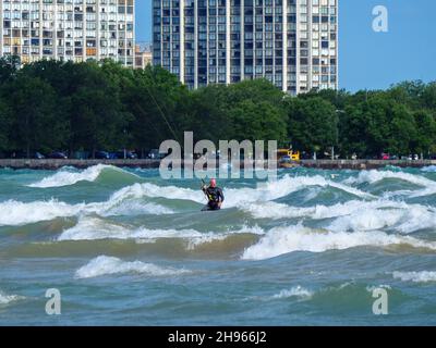 Ein Mann mittleren Alters kitesurft am Montrose Beach in Chicago. Stockfoto