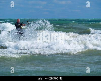 Ein Mann mittleren Alters kitesurft am Montrose Beach in Chicago. Stockfoto