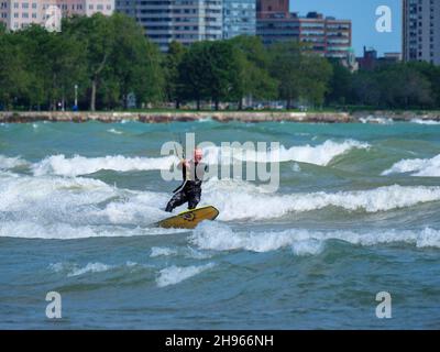 Ein Mann mittleren Alters kitesurft am Montrose Beach in Chicago. Stockfoto