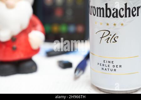 Stuttgart, 04. Dezember 2021: Krombacher Bierkisten auf dem Schreibtisch. Weihnachtsmann und Bürobedarf im Hintergrund. Alkoholkonsum bei wor Stockfoto