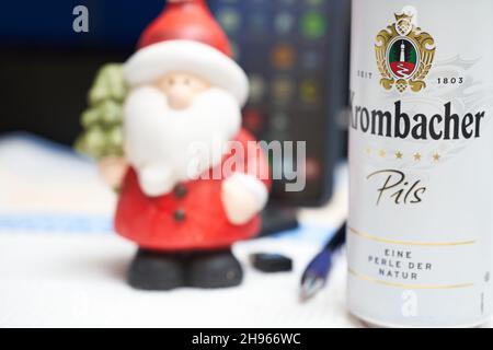 Stuttgart, 04. Dezember 2021: Krombacher Bierkisten auf dem Schreibtisch. Weihnachtsmann und Bürobedarf im Hintergrund. Alkoholkonsum bei wor Stockfoto