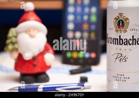 Stuttgart, 04. Dezember 2021: Krombacher Bierkisten auf dem Schreibtisch. Weihnachtsmann und Bürobedarf im Hintergrund. Alkoholkonsum bei wor Stockfoto