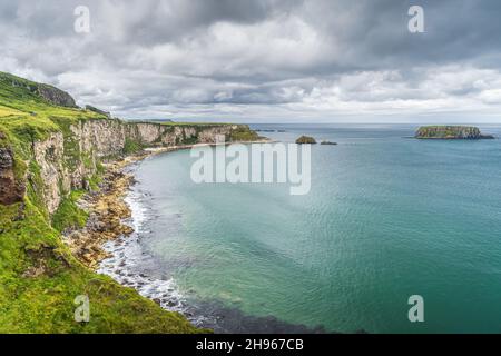 Küste mit hohen Kalksteinfelsen, Sheep Island und türkisfarbenem Atlantischen Ozean, in der Nähe der Carrick a Rede-Hängebrücke, Wild Atlantic Way, Nordirland Stockfoto