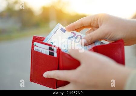 Person, die 20 Euro Geld aus ihrer Brieftasche herausnimmt. Geld zählen, Wirtschaftskonzept, Geldverteilung Stockfoto