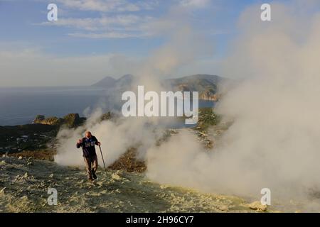 Ein italienischer Vulkanologe des INGV arbeitet am Hauptkrater von Vulcano Island. Der Bürgermeister der Insel, der Vulkane ihren Namen gab, verbietet auch Touristen nach dem Anstieg schwefelhaltiger Gase. Nach Angaben des Nationalen Instituts für Geophysik und Vulkanologie (INGV) hat es eine Zunahme schwerer Gase gegeben, die die Sauerstoffmenge in der Luft reduzieren, was Atembeschwerden verursacht, die tödliche Auswirkungen haben können. Stockfoto