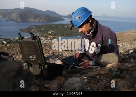 Ein italienischer Vulkanologe des INGV arbeitet am Hauptkrater von Vulcano Island. Der Bürgermeister der Insel, der Vulkane ihren Namen gab, verbietet auch Touristen nach dem Anstieg schwefelhaltiger Gase. Nach Angaben des Nationalen Instituts für Geophysik und Vulkanologie (INGV) hat es eine Zunahme schwerer Gase gegeben, die die Sauerstoffmenge in der Luft reduzieren, was Atembeschwerden verursacht, die tödliche Auswirkungen haben können. Stockfoto