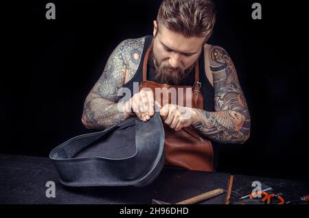 Handwerker, der mit Leder arbeitet, der auf sein Geschäft aus ist Stockfoto