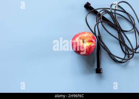 Springseil und Apfel isoliert auf blau, kopieren Raum. Stockfoto