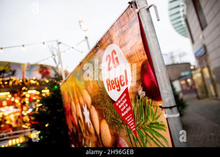 Delmenhorst, Deutschland. 04th Dez 2021. Am Eingang zum Weihnachtsmarkt am Rathausplatz hängt ein Schild mit der Aufschrift „2G Plus Rule“. Auf dem eingezäunten Weihnachtsmarkt in der Innenstadt gelten 2G und eine Maskenpflicht. Quelle: Hauke-Christian Dittrich/dpa/Alamy Live News Stockfoto