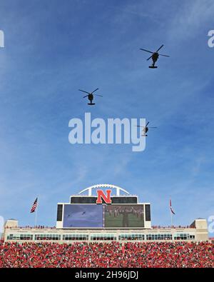 Drei Hubschrauber der Nebraska Army National Guard UH-60L Blackhawk fliegen 15 Minuten vor dem Start zwischen der University of Nebraska Cornhuskers und den Football-Teams der University of Iowa Hawkeyes am 26. November 2021 in Lincoln über das Memorial Stadium. (USA Foto der Armee-Nationalgarde von Maj. Scott Ingalsbe) Stockfoto