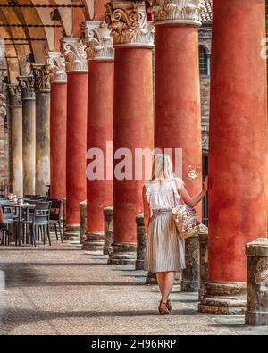 Bologna, die historische Hauptstadt der Region Emilia-Romagna, in Norditalien. Die Piazza Maggiore ist eine weitläufige plaza, die von roten Bogenkolonnaden gesäumt ist. Stockfoto