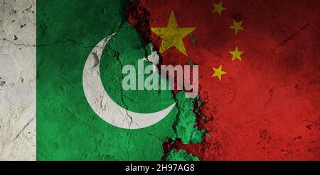 Pakistan gegen china flaggen vor einem rauen Hintergrund. Gebrochener und rissiger Hintergrund. Stockfoto