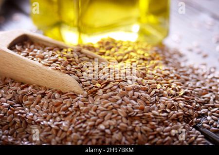 Flachs Öl und Rohstoffe Saatgut in Holz- Schaufel auf Küchentisch closeup Stockfoto