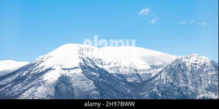 Atemberaubende Aussicht auf eine schneebedeckte Bergkette an einem sonnigen Tag. Stockfoto