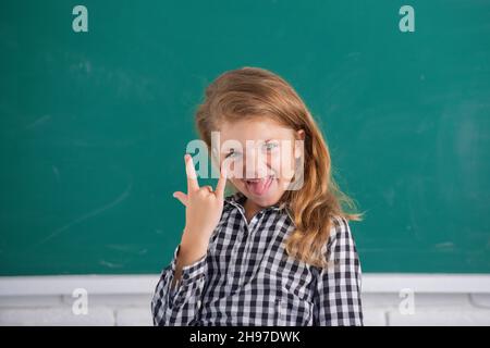 Porträt von lustigen Schüler Mädchen der Grundschule Studie. Lustige Mädchen in der Schule. Grundschulkind in der Klasse. Witzige Zunge. Stockfoto