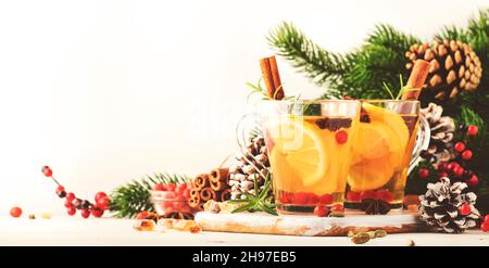 Heißer Winter-Tee mit Zitrone, Preiselbeeren, Kräutern und Gewürzen in der Weihnachts- oder Neujahrseinstellung, weißer Hintergrund, Kopierraum Stockfoto