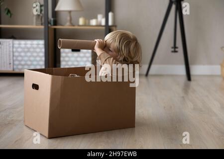 Verträumter kleiner Vorschuljunge, der zu Hause Seemann spielt Stockfoto